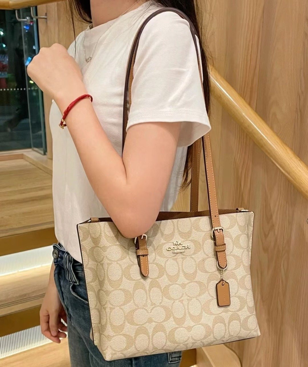 Coach Patterned Tote Bag with Tan Buckle Handles — model