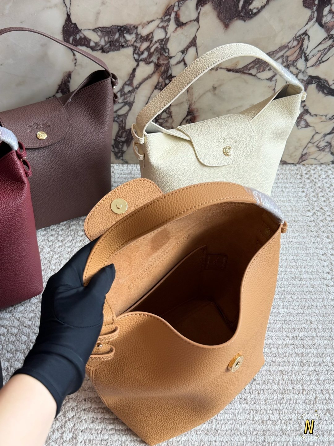 Longchamp Pebbled Bucket Bag with Rounded Snap Flap — comparison